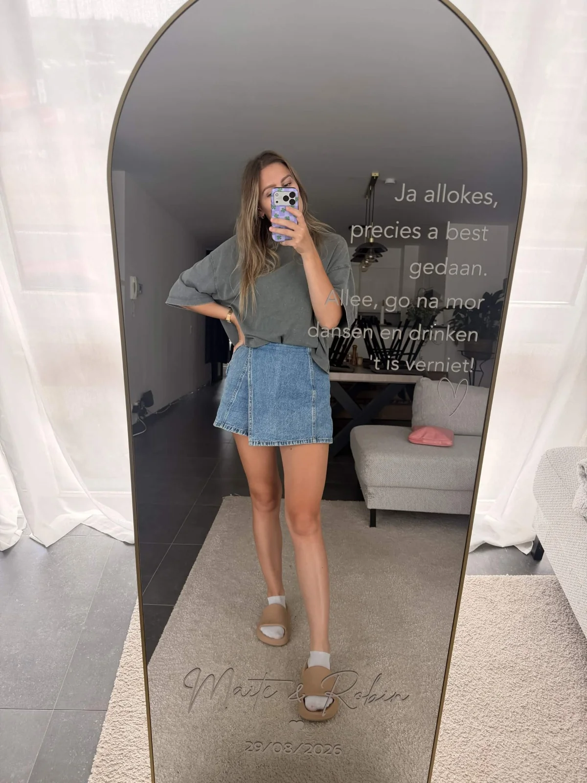 Lifestyle photo of a personalised wedding mirror with a person standing in the reflection